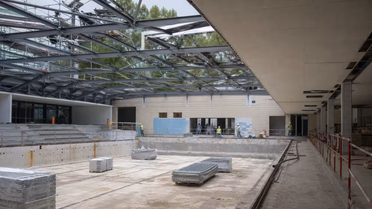 Charpente métallique en cours de remplacement dans le hall d’une piscine municipale en rénovation