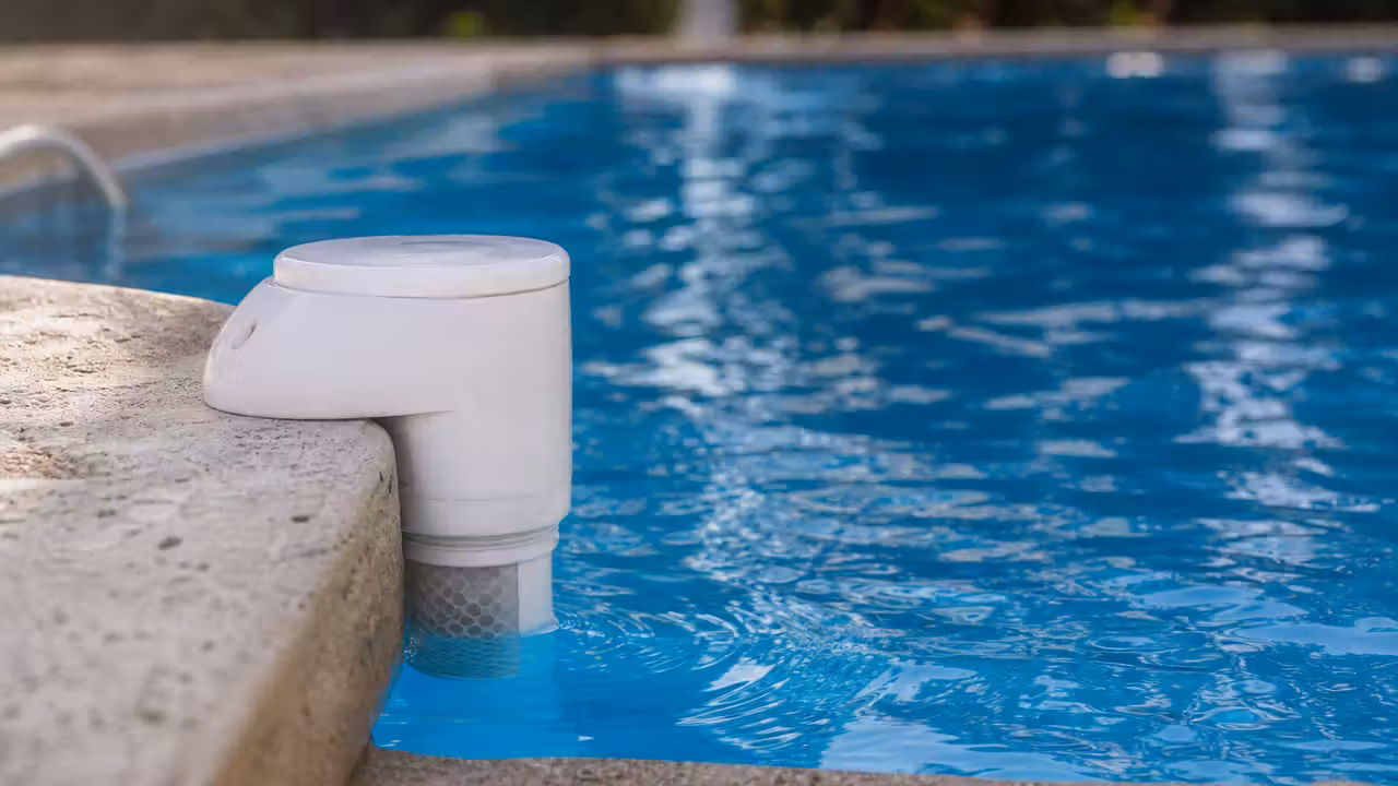 Boîtier d'alarme immergée de piscine fixé sur la margelle au bord d'un bassin, capteur visible sous l'eau