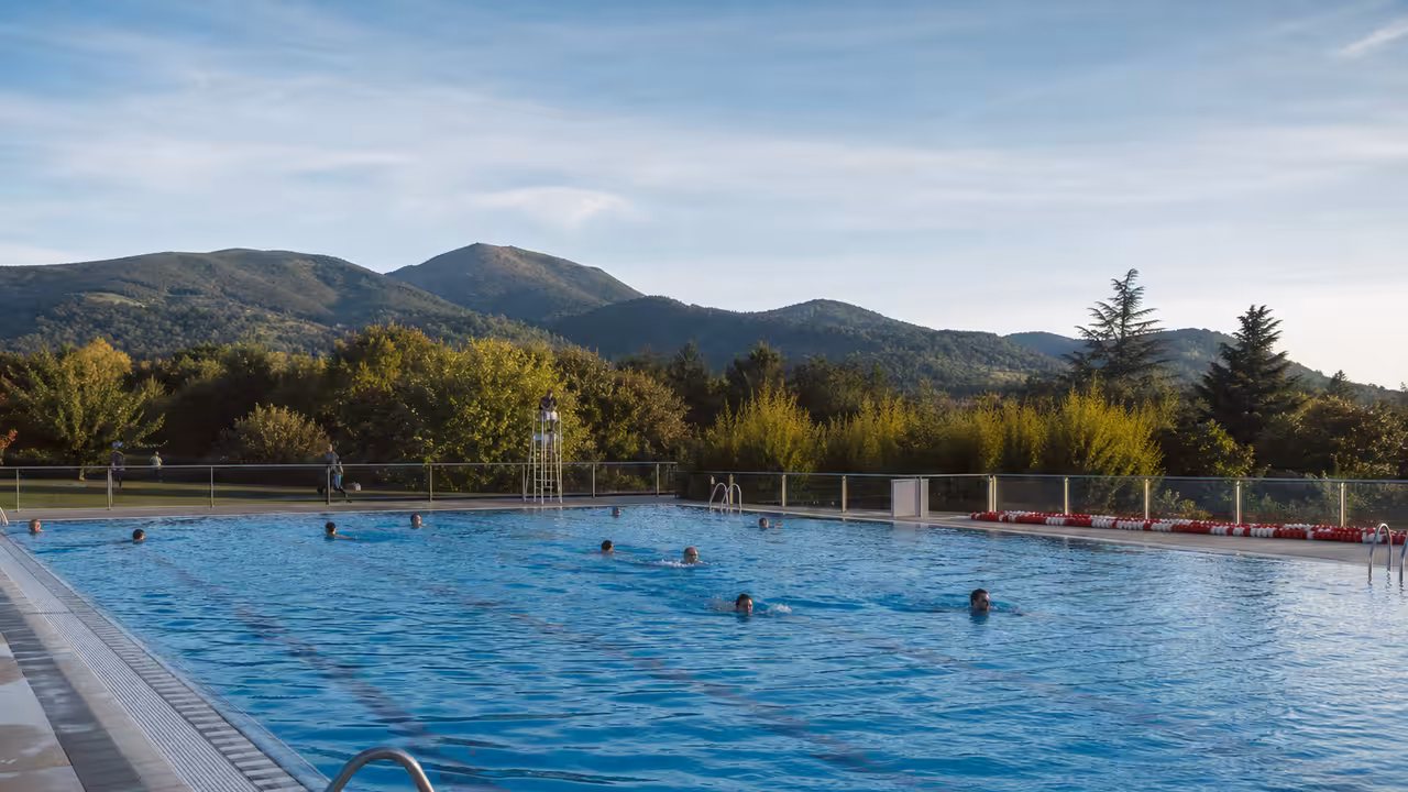 Bassin extérieur d’une piscine municipale au pied des reliefs basques, par une lumineuse journée d’automne