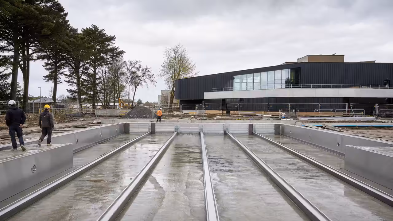 Chantier d’extension d’un centre aquatique avec bassin extérieur de nage et structures métalliques