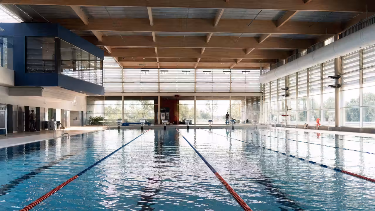 Nageurs effectuant des longueurs dans un bassin couvert à plusieurs lignes d'eau dédiées au sport