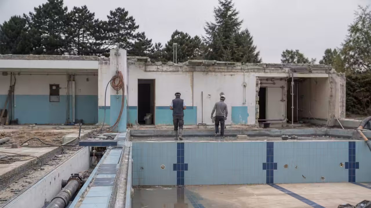 Chantier de rénovation d’une piscine publique avec bassin vidé et équipements techniques apparents