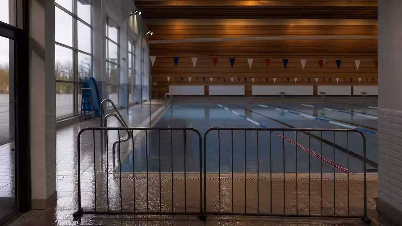 Entrée d’une piscine municipale bordelaise fermée temporairement, avec bassin intérieur vide en arrière-plan