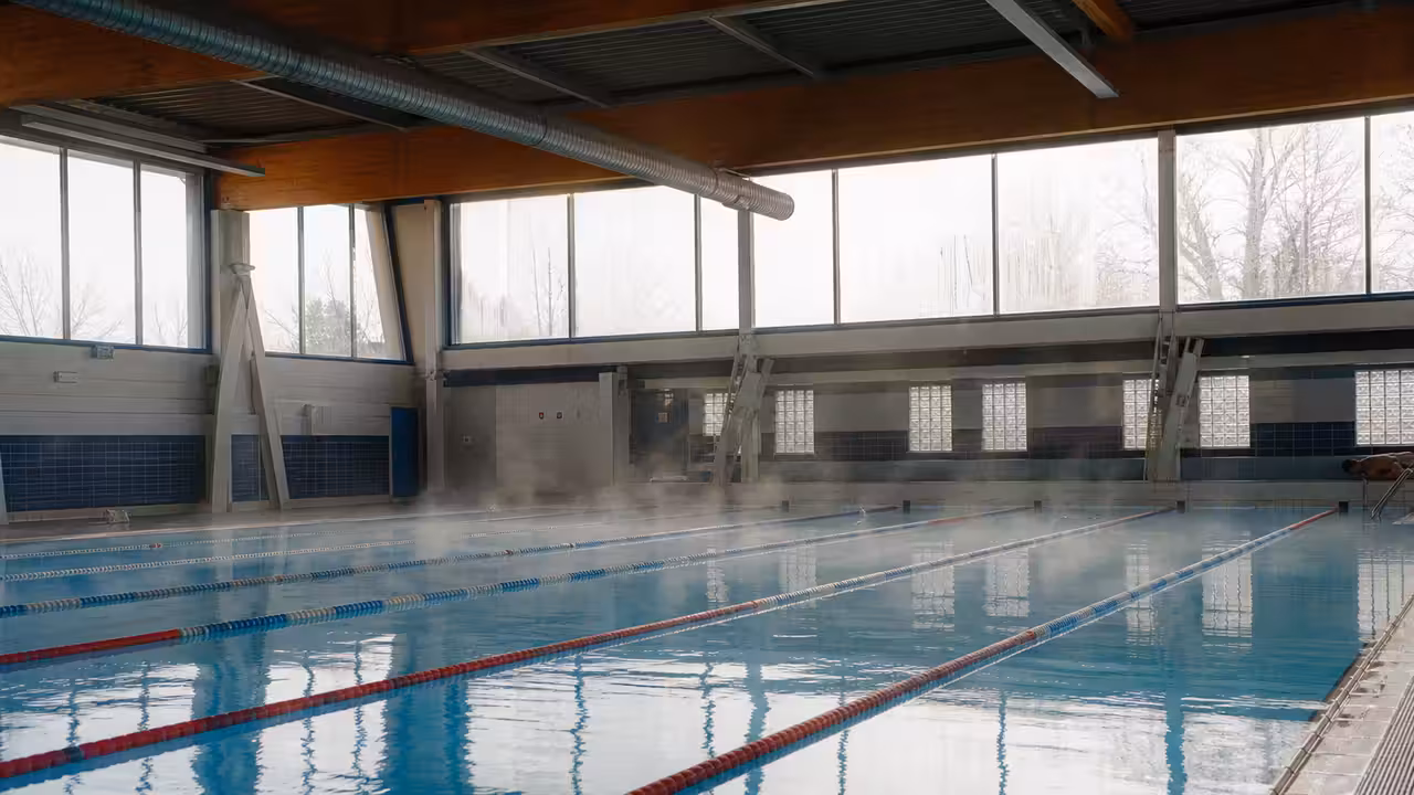 Bassin intérieur municipal aux lignes d’eau calmes, sous une lumière naturelle, préparé pour l’ouverture au public