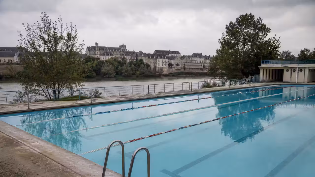 Bassin nordique extérieur vide au bord de la Rance, avec l’abbaye de Léhon visible en arrière-plan