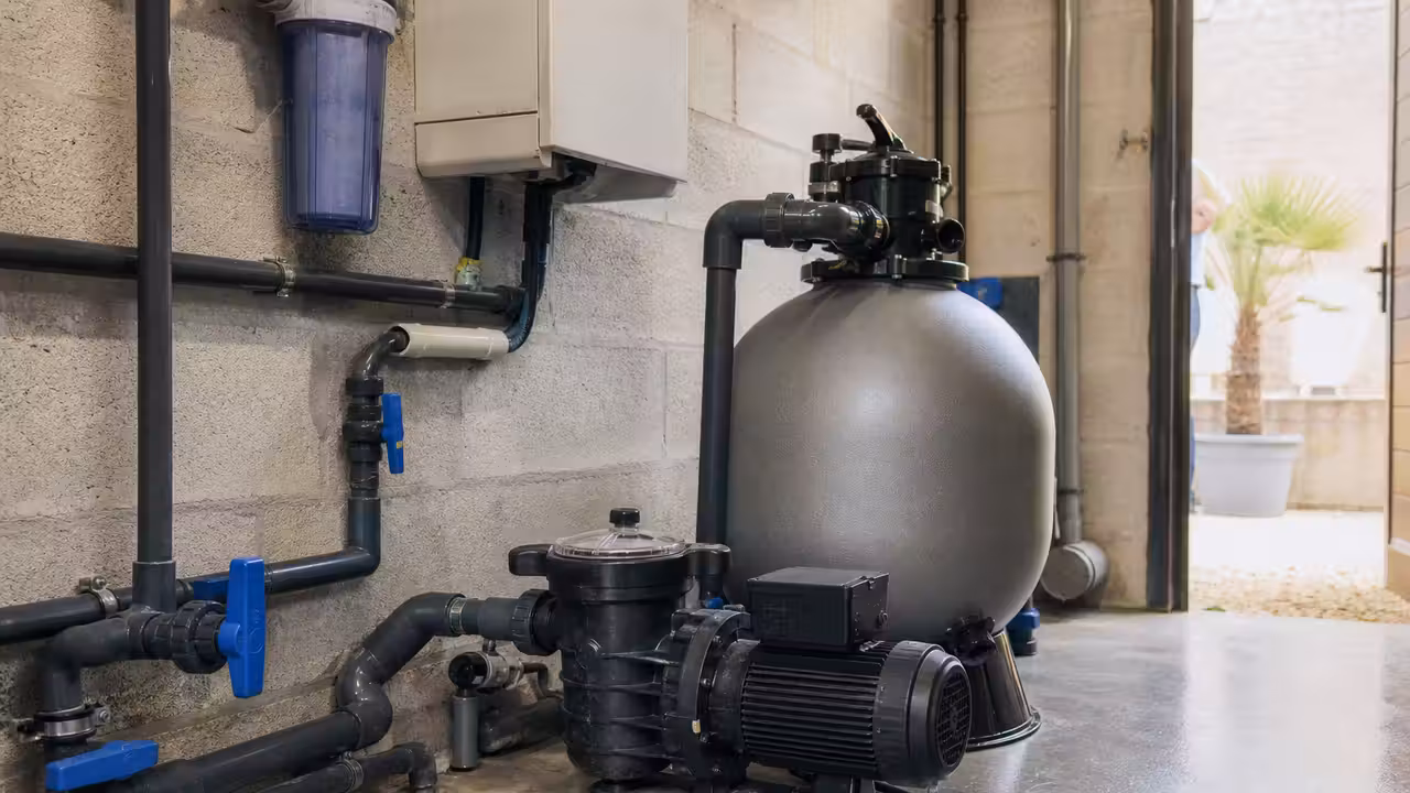 Pompe de filtration neuve raccordée à un filtre dans un local technique de piscine propre et lumineux