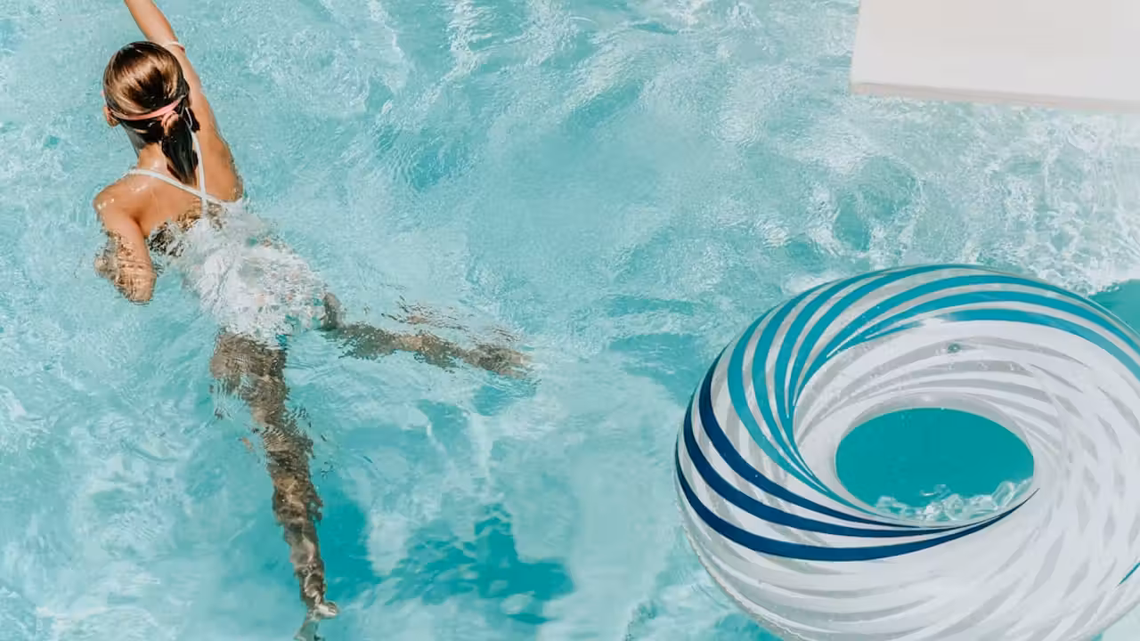 Bassin couvert de 25 mètres dans un centre aquatique moderne, avec lignes d’eau et lumière naturelle