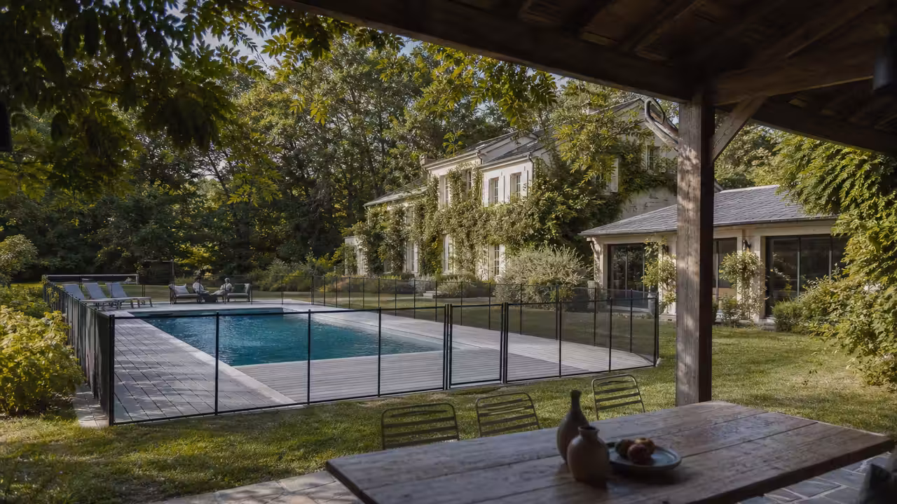 Villa contemporaine en Île-de-France avec piscine extérieure, terrasse en bois et jardin arboré au soleil