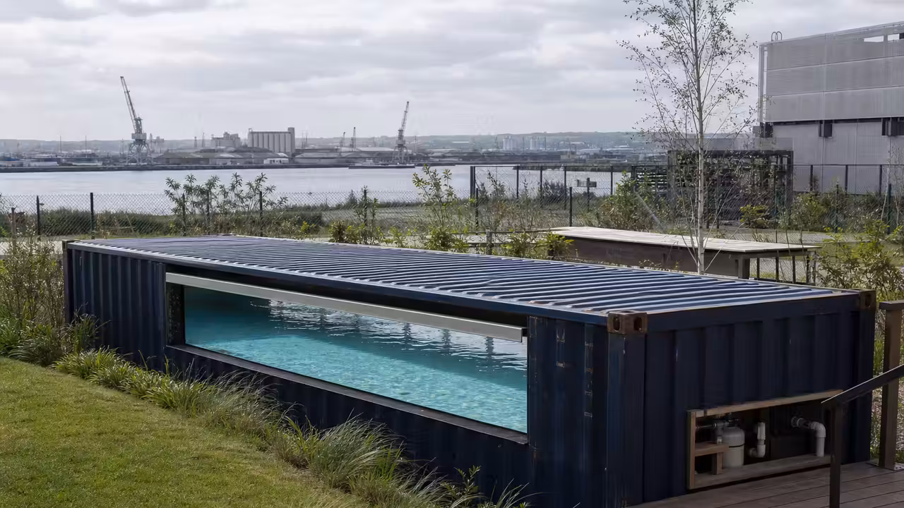 Piscine étroite aménagée dans un conteneur maritime sur une terrasse, avec structure métallique apparente
