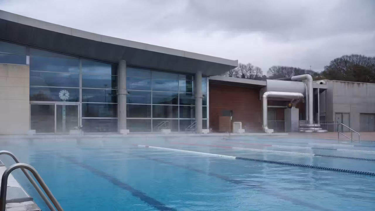 Bassin extérieur de piscine publique chauffé, avec une légère vapeur au-dessus de l’eau par temps frais