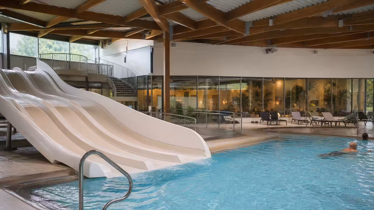 Pentagliss à plusieurs pistes et espace de bassin dans une piscine publique moderne et lumineuse