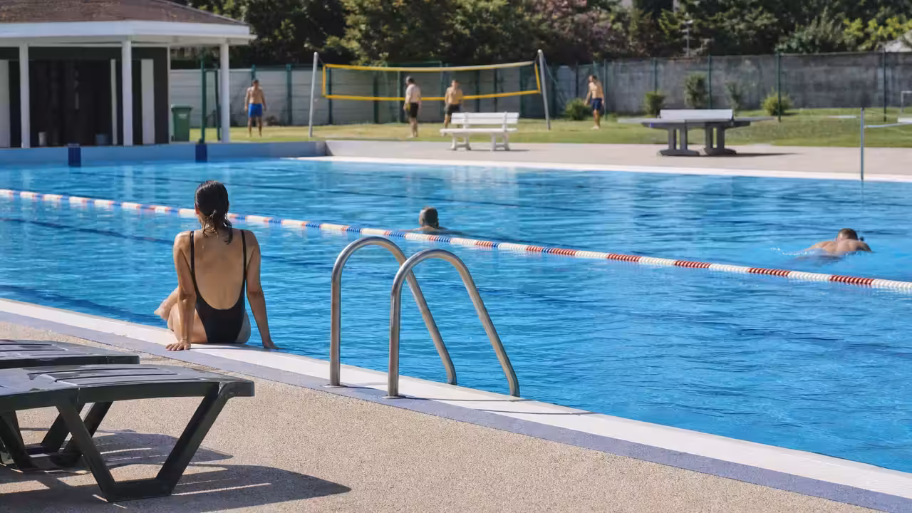 Bassin d’une piscine publique française avec lignes d’eau calmes et espace de détente sur le bord