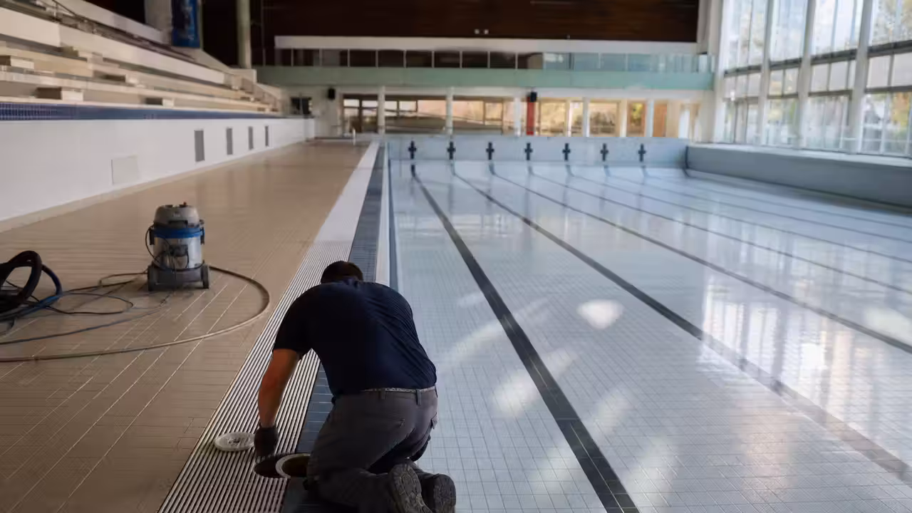 Technicien inspectant un bassin public vidé pendant une opération d’entretien et de nettoyage