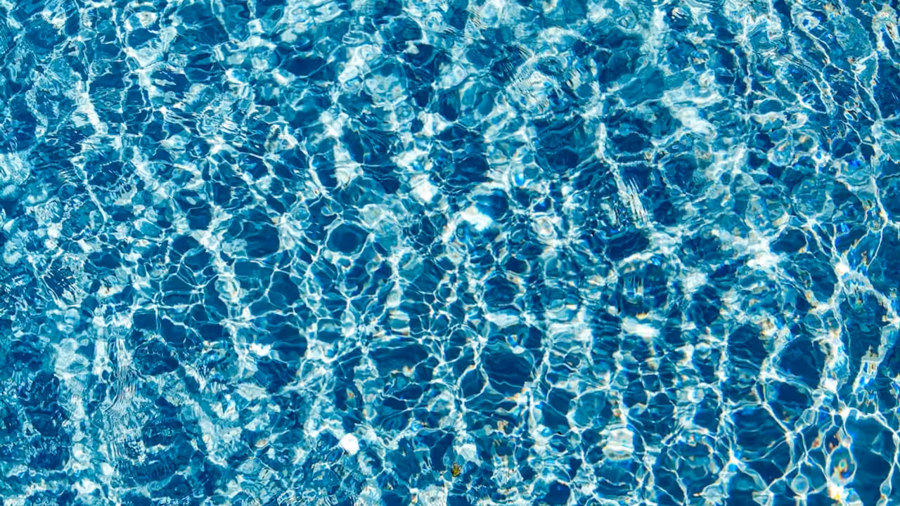 Perspective réaliste d’une piscine publique moderne avec bassin extérieur, bâtiment vitré et espaces paysagers