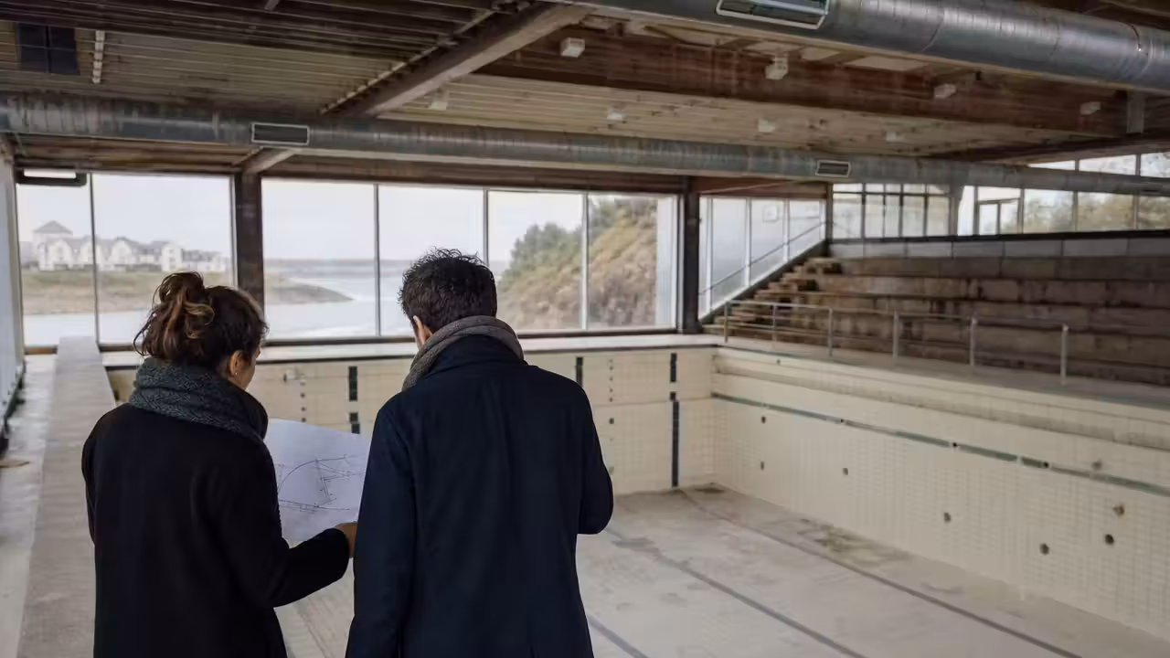Façade d’un ancien équipement aquatique municipal en cours de réaménagement dans un quartier urbain