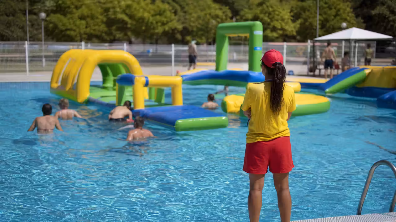Nageurs adultes et encadrant lors d’une animation aquatique dans un bassin public estival