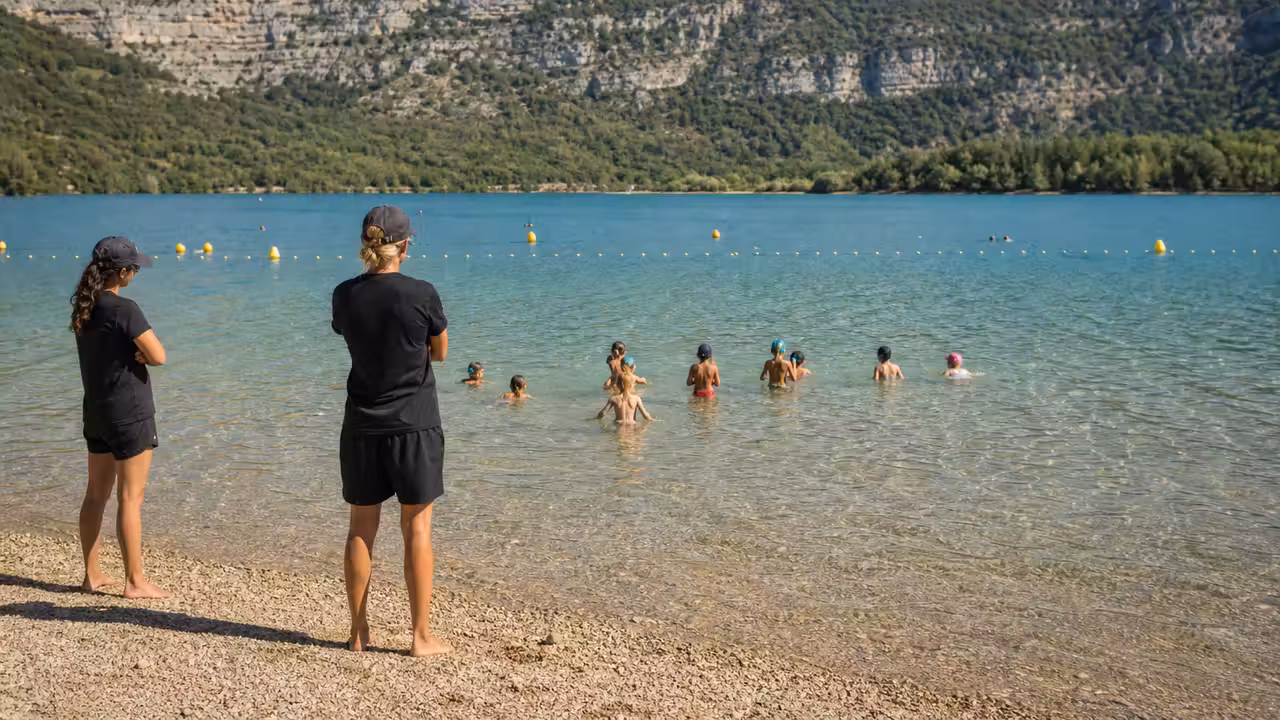 Groupe d’enfants encadrés près d’une zone de baignade calme au lac de Sainte-Croix