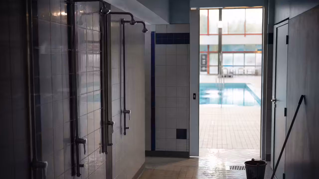 Bassin municipal vide avec lignes d’eau et accès aux douches fermé pendant une opération sanitaire