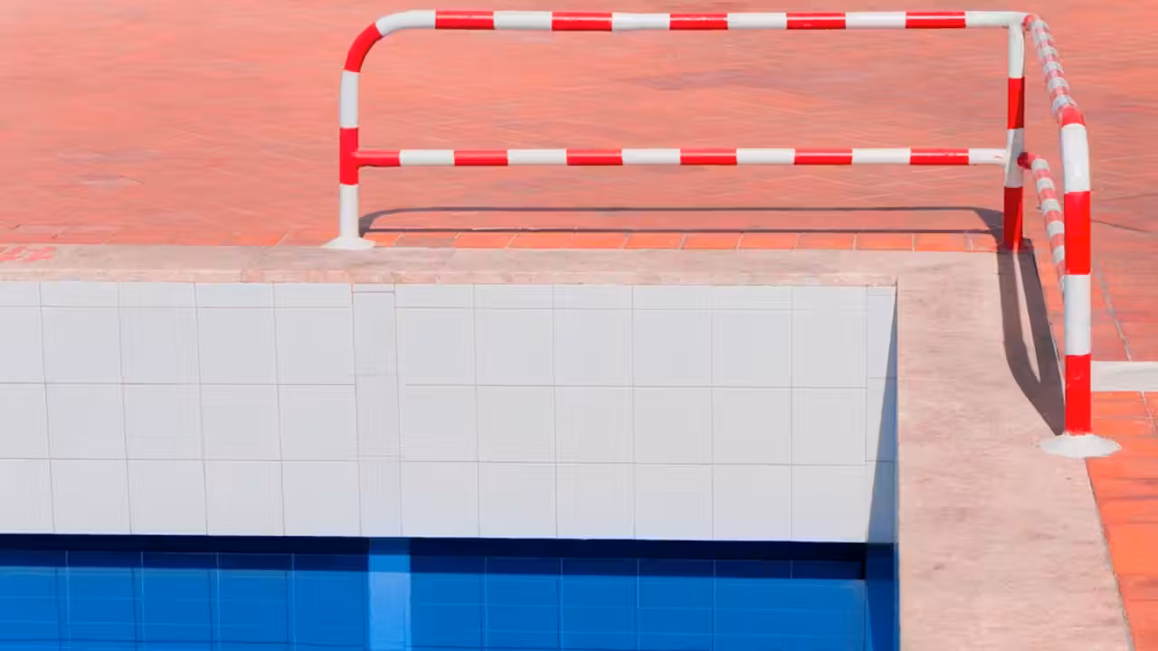 Technicien inspectant des canalisations dans le local technique d’une piscine publique fermée pour fuite