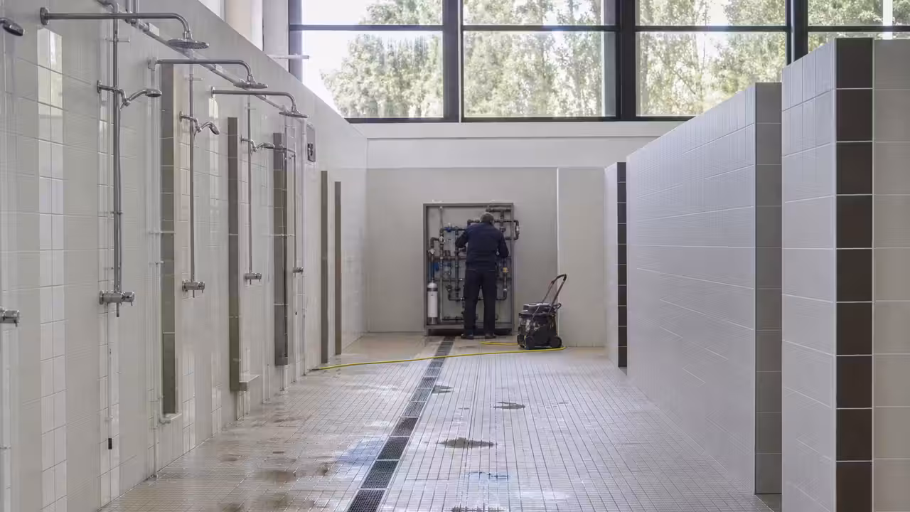 Vestiaires lumineux et inoccupés d’un centre aquatique pendant une intervention de maintenance technique