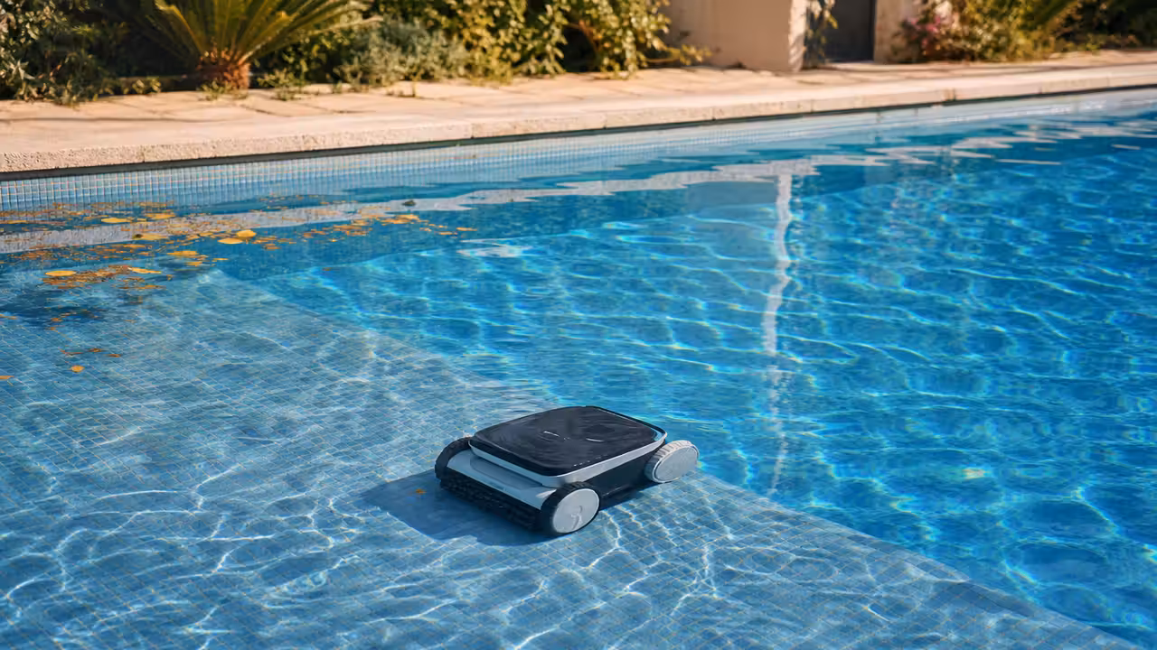 Robot électrique nettoyant le fond carrelé d'une piscine privée avec reflets d'eau et panier filtrant visible