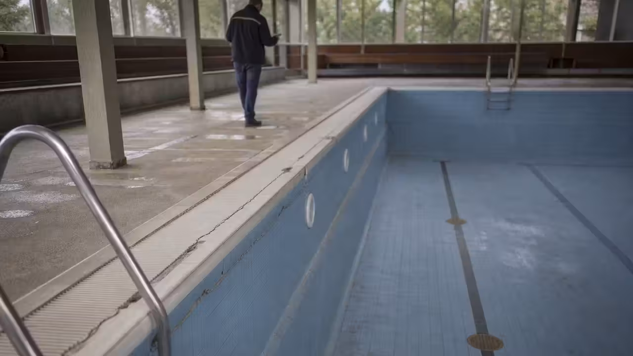 Bassin de piscine publique vidé, avec inspection des parois et du fond avant travaux de réparation