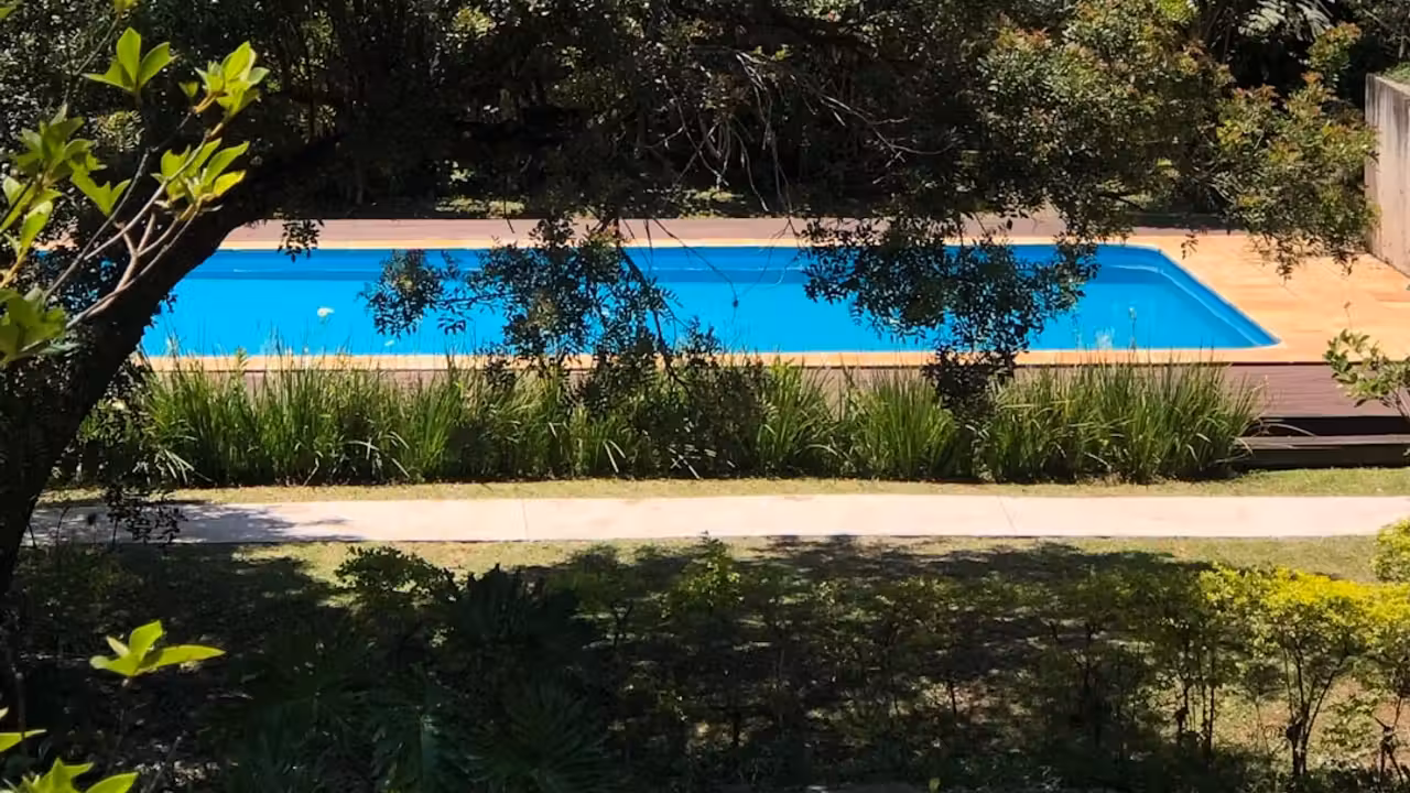 Bassin intérieur rénové d'une piscine municipale, avec lignes d'eau, plage claire et vestiaires en arrière-plan
