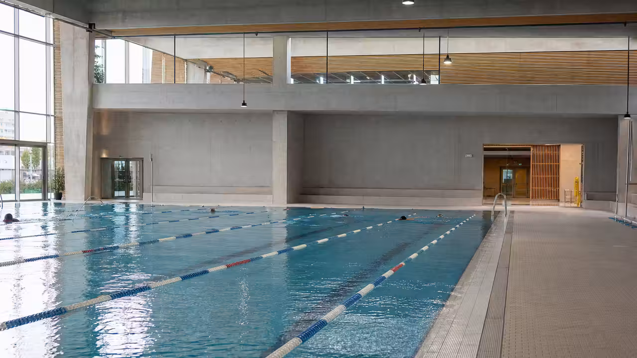 Bassin sportif de 50 mètres avec lignes d’eau dans un centre aquatique public moderne et lumineux