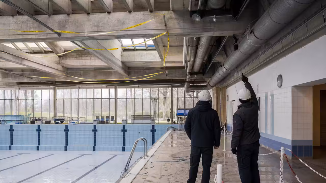 Bassin couvert municipal vide, rubalisé pendant l’inspection d’un plafond par des techniciens équipés