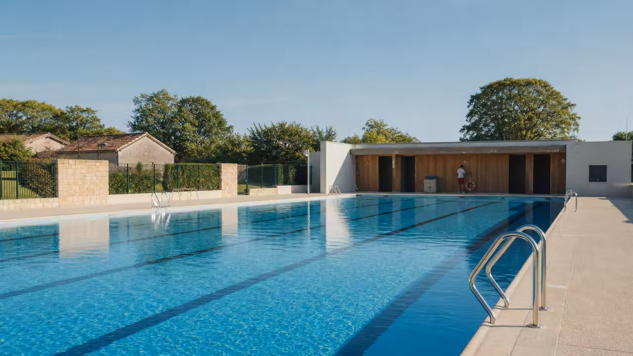 Bassin extérieur d’une piscine municipale rénovée, avec lignes d’eau et plages propres avant l’ouverture estivale