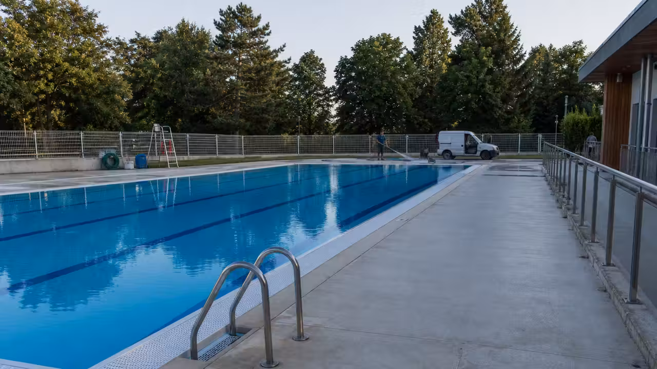 Bassin extérieur d’une piscine municipale préparé avant l’été, avec lignes d’eau et plages nettoyées