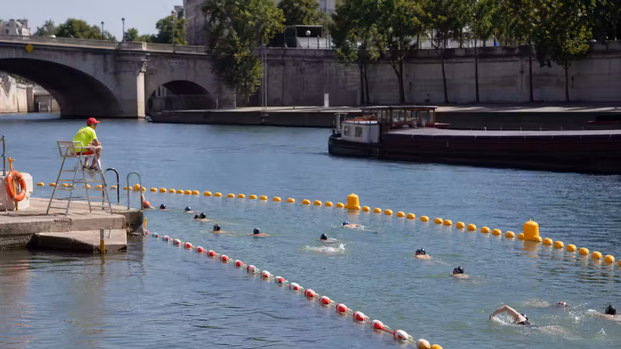 Zone de baignade urbaine aménagée au bord d’un fleuve, séparée du chenal par des barrières flottantes