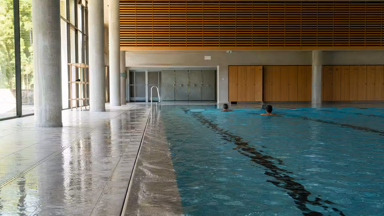Vue intérieure lumineuse d’un bassin sportif de 25 mètres dans une piscine publique moderne à Uzès