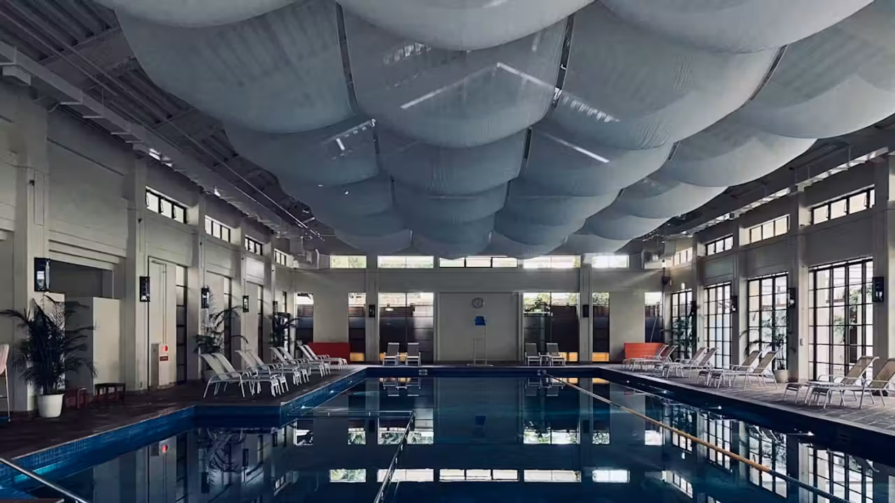 Bassin de natation de 50 mètres avec lignes d’eau et gradins dans un centre aquatique moderne