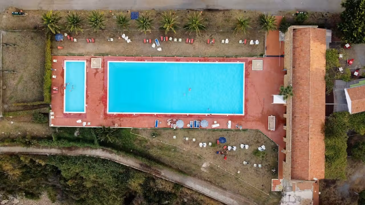 Bâtiment de piscine municipale fermé, avec bassin vide et équipements techniques en cours de dépose