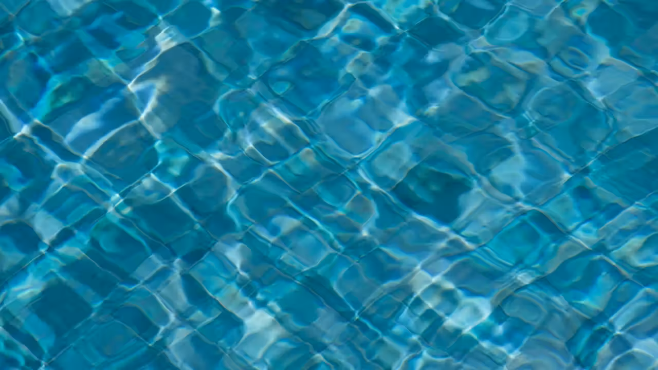 Technicien de piscine contrôlant le pH et le chlore d’un bassin extérieur à l’aide d’un kit d’analyse