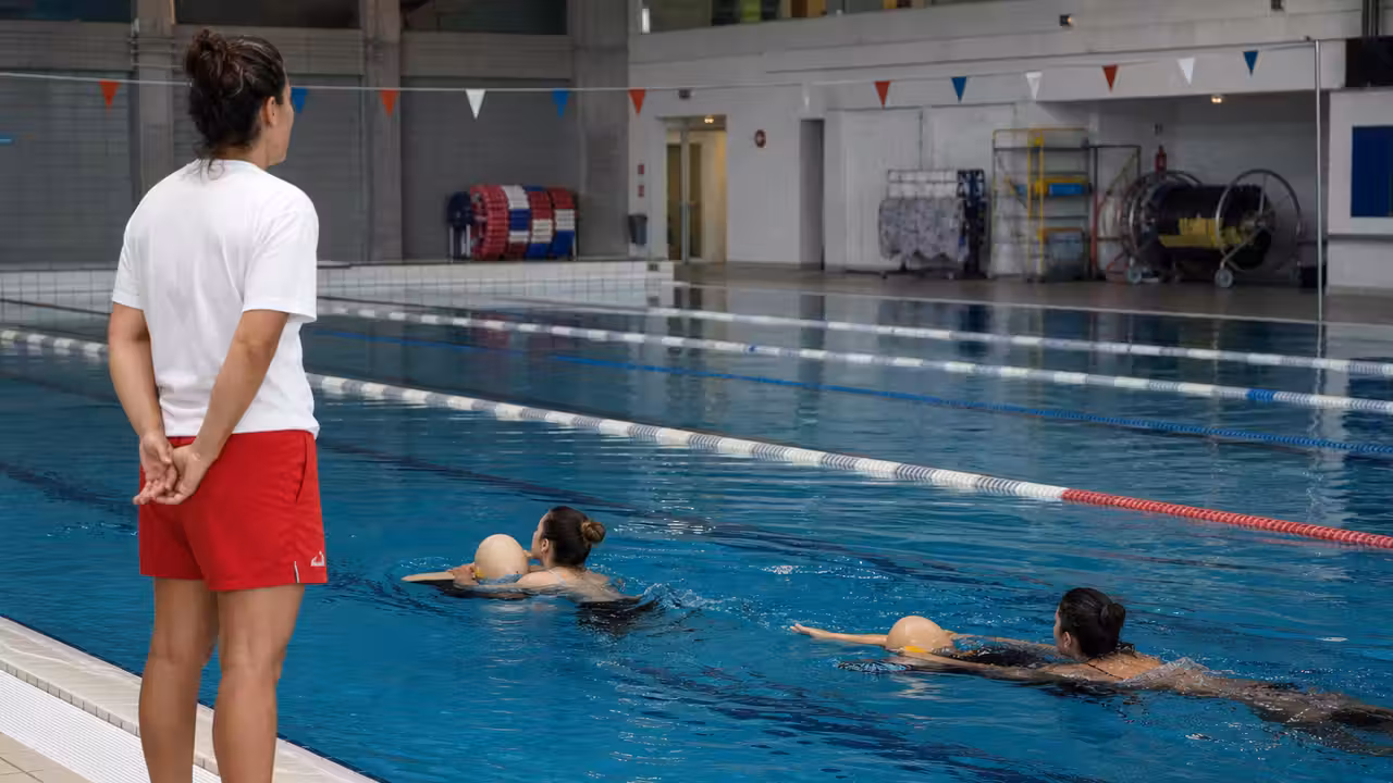 Entraînement de sauvetage aquatique avec mannequin dans un bassin couvert de piscine publique