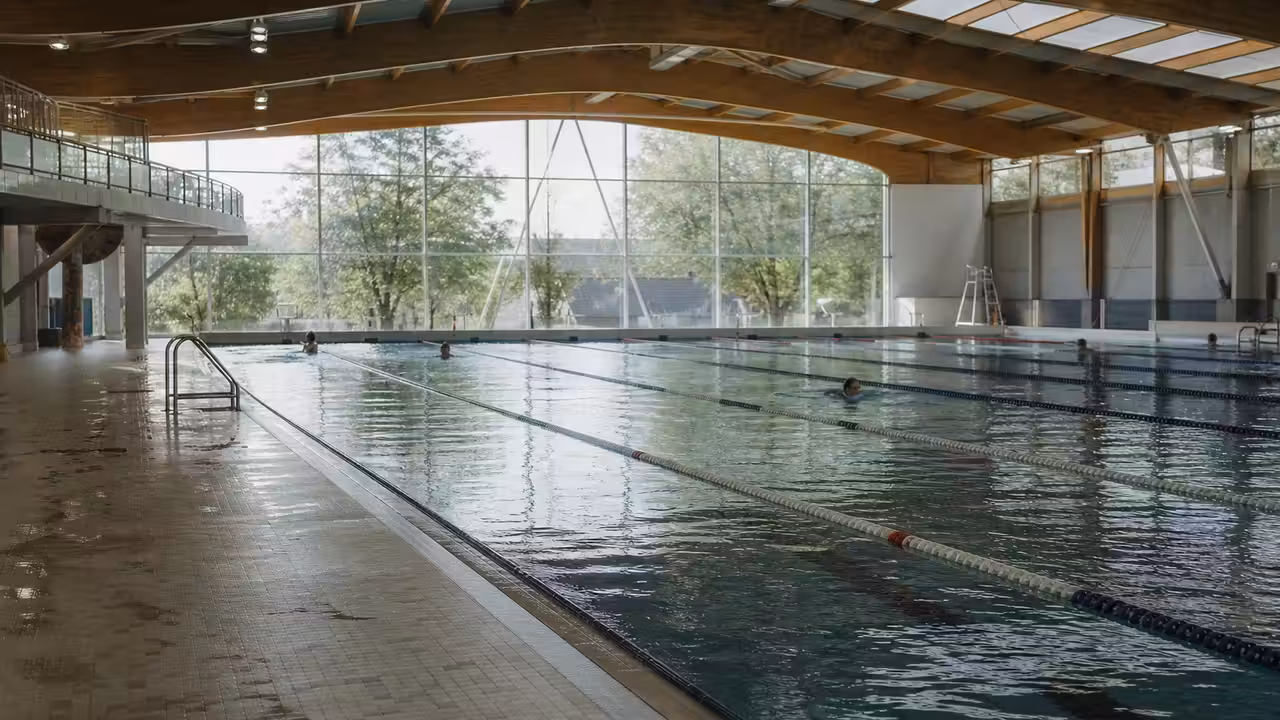 Centre aquatique moderne en Seine-Saint-Denis, avec bassin sportif et lumière naturelle sous une charpente en bois
