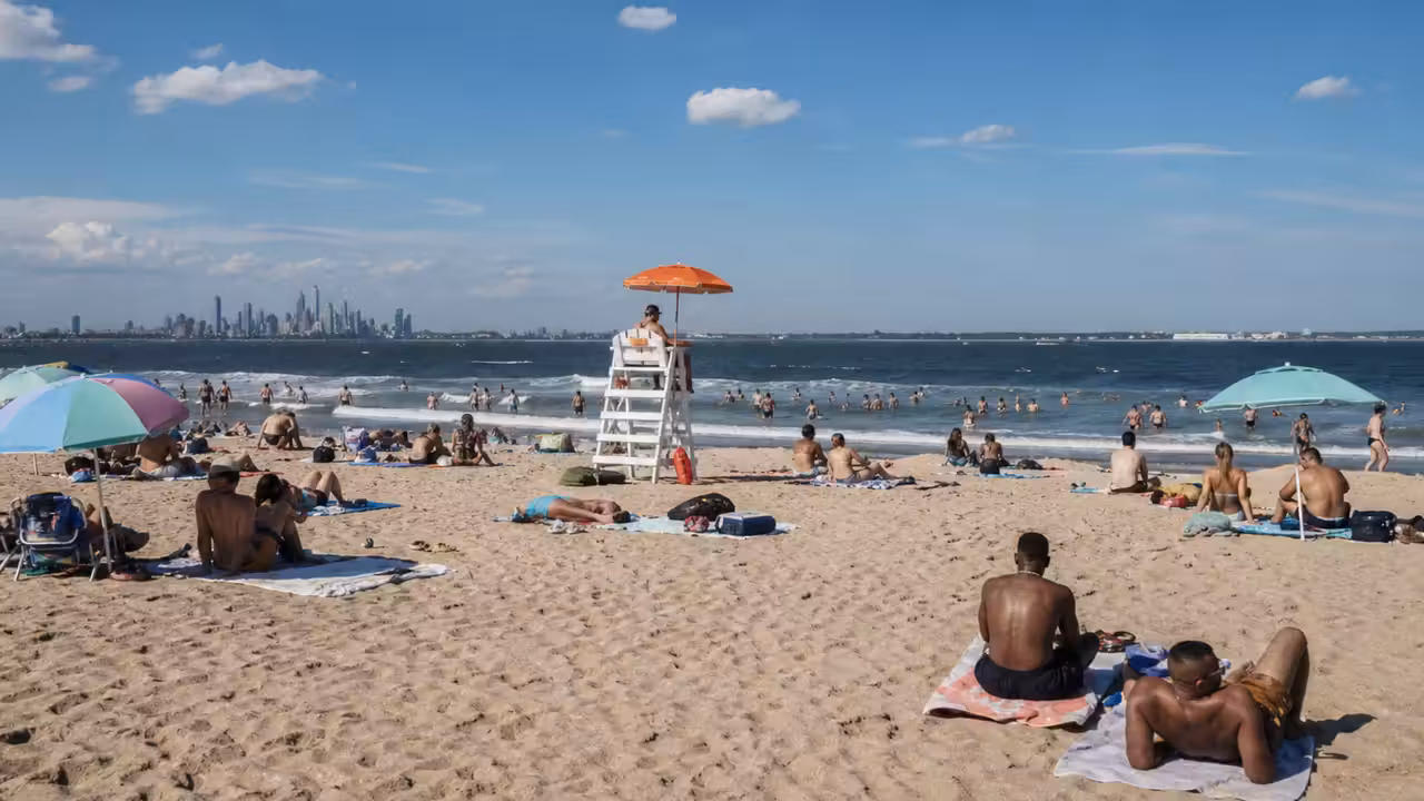 Baigneurs sur la plage de Rockaway à New York, face aux vagues de l’Atlantique et aux postes de surveillance