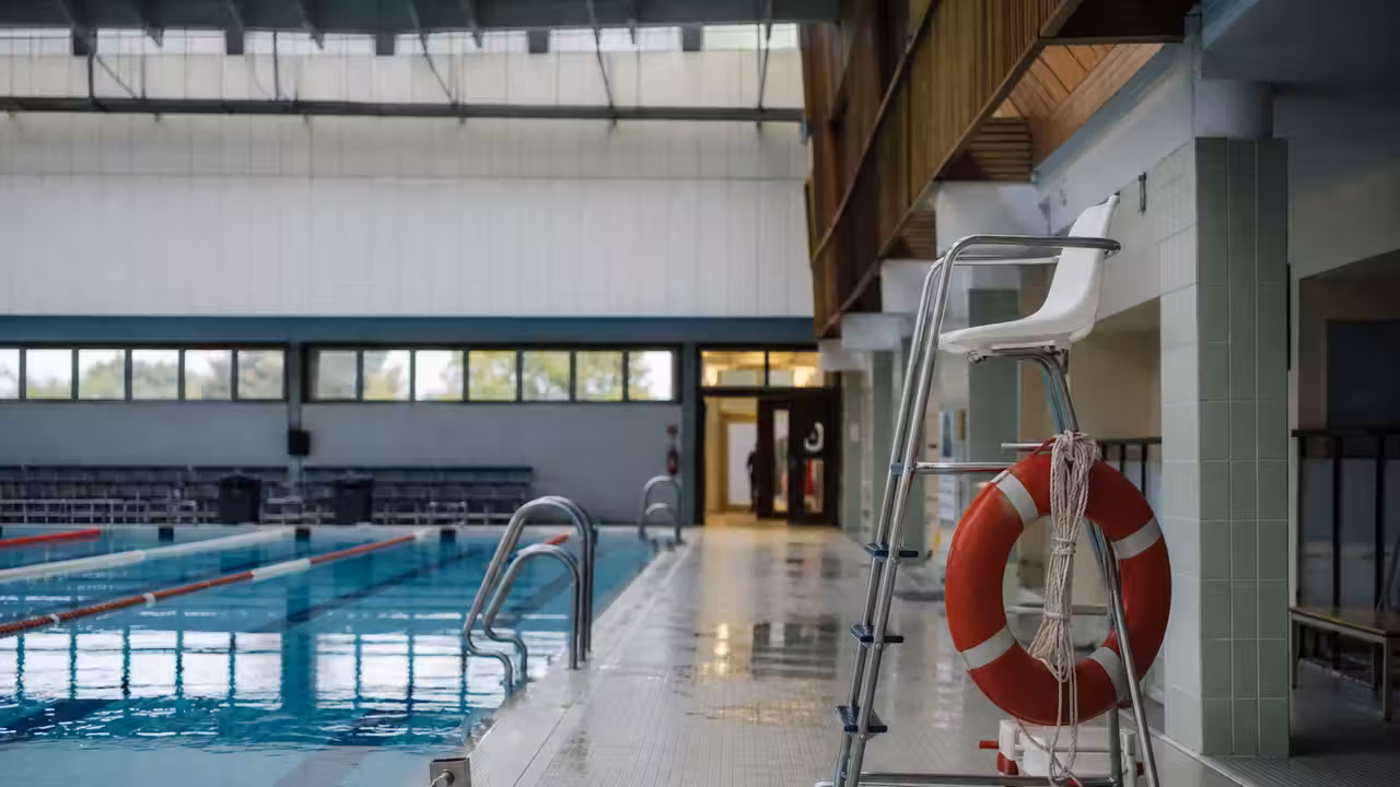 Lignes d’eau calmes dans une piscine municipale vide avant l’ouverture au public