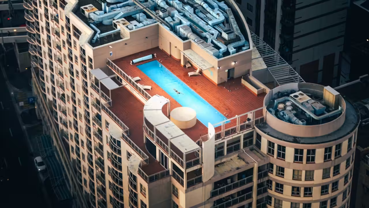 Vue extérieure d’un centre aquatique contemporain en Bretagne, avec façade vitrée et végétation locale.