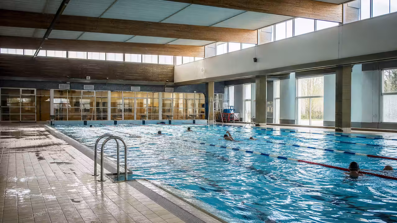 Bassin sportif extérieur de 50 mètres dans un centre aquatique municipal, vide avant l'ouverture