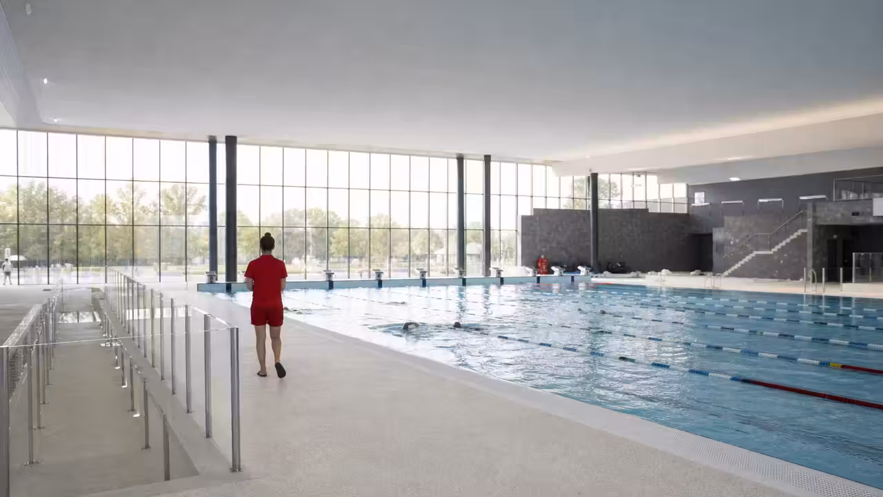 Vue intérieure d’un centre aquatique moderne avec bassin de nage, baies vitrées et plages humides accessibles