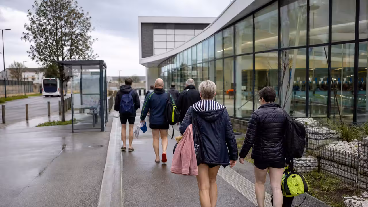 Entrée contemporaine d’un centre aquatique avec arrêt de bus et voyageurs près de Combourg