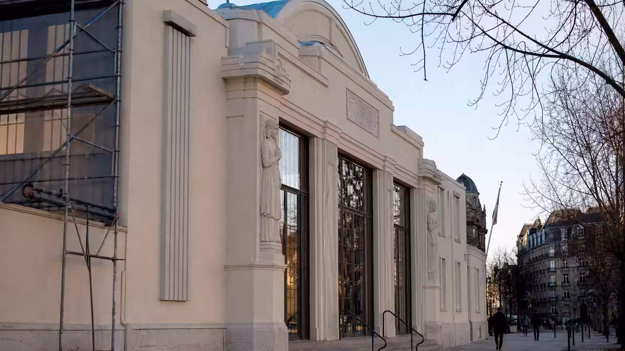 Façade Art déco d’une piscine municipale en restauration, avec échafaudage et détails géométriques préservés