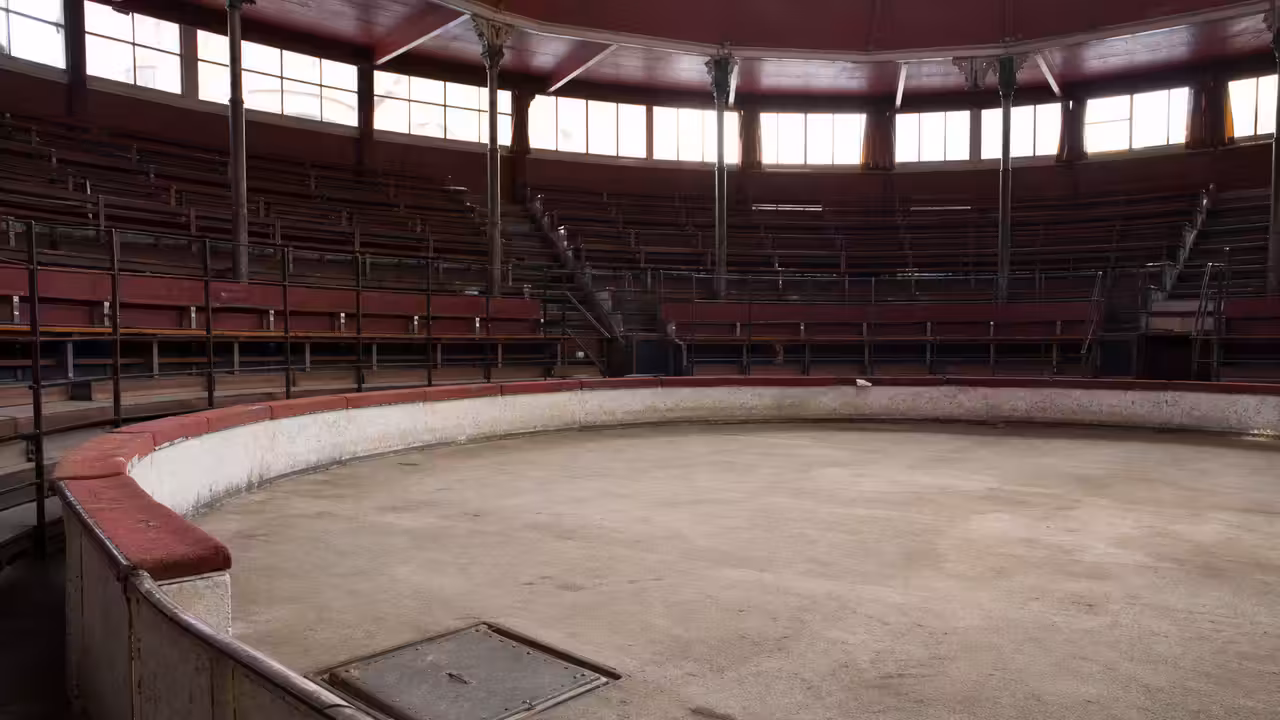 Piste circulaire vide d’un cirque historique évoquant un bassin technique dissimulé sous le sol