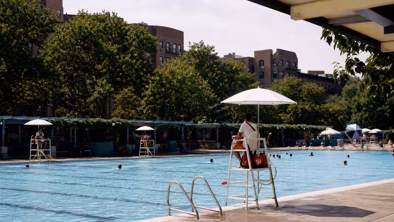 Bassin municipal extérieur de New York avec lignes d’eau, gradins et immeubles urbains en arrière-plan