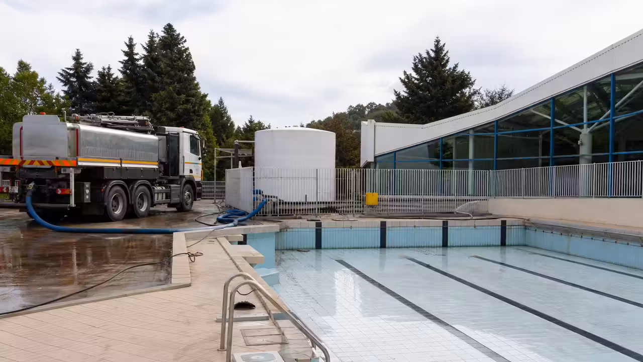 Camion-citerne près d’une piscine municipale lors d’un transfert d’eau vers une réserve incendie