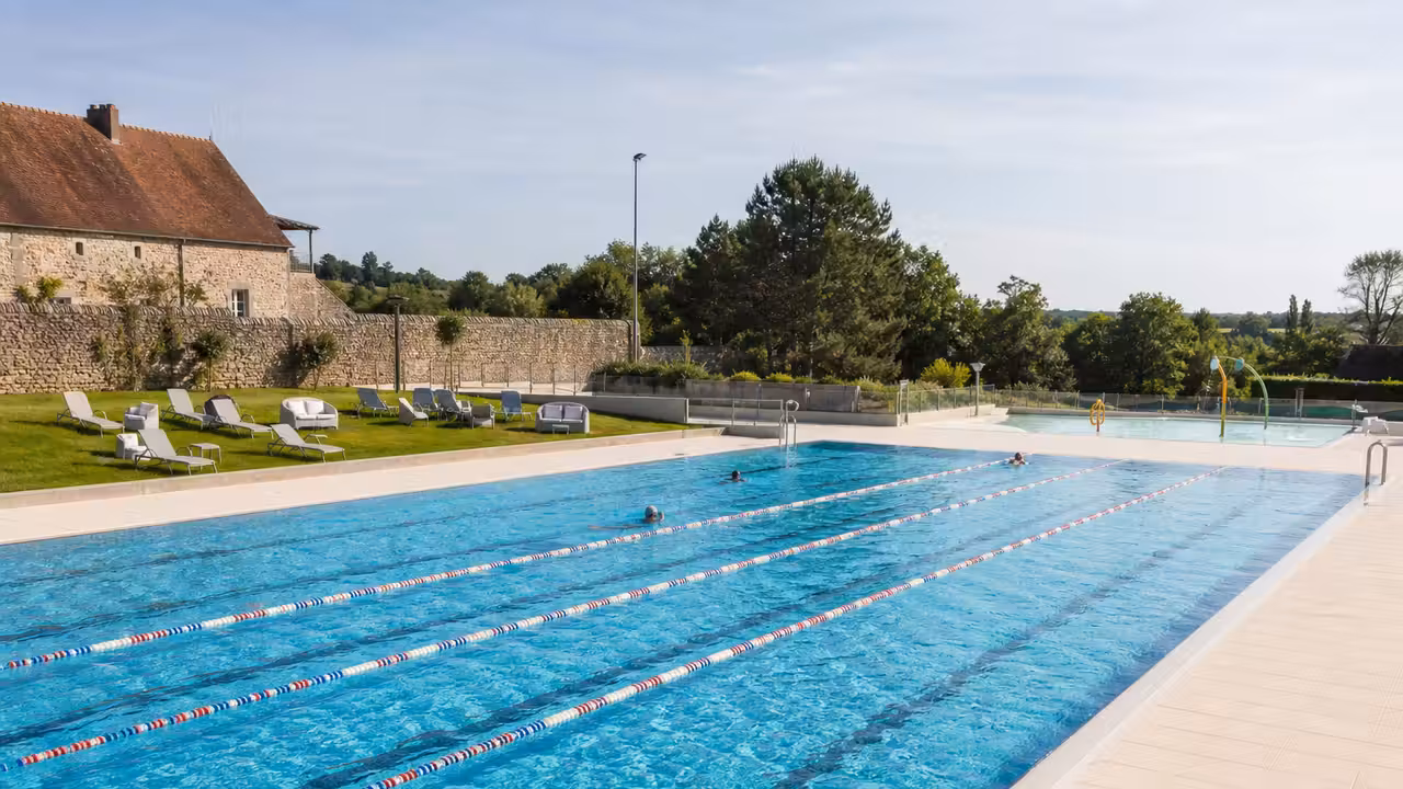 Grand bassin de 25 mètres et solarium enherbé d’une piscine publique rénovée en Nouvelle-Aquitaine