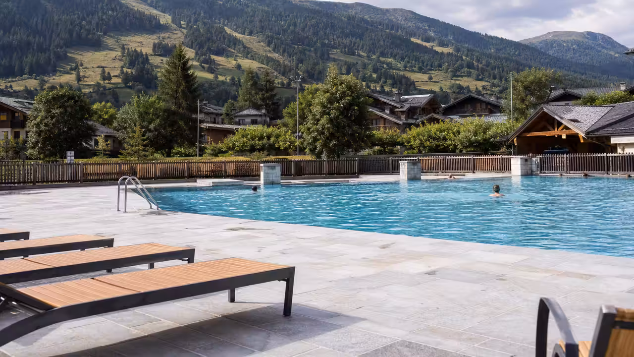 Vue en plongée d’un bassin municipal de montagne entouré de plages et de bâtiments rénovés